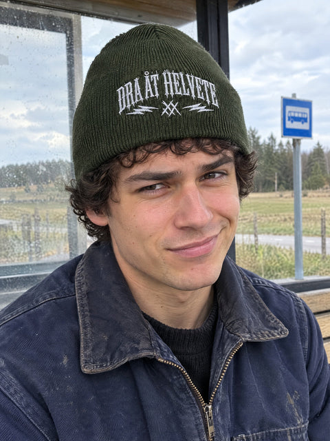 Dra åt helvete på olivgrön Hatitude Beanie, buren av en yngre vuxen.