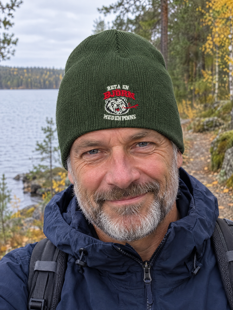 Olivengrønn Beanie uten oppbrett med bjørnebroderi på modell utendørs