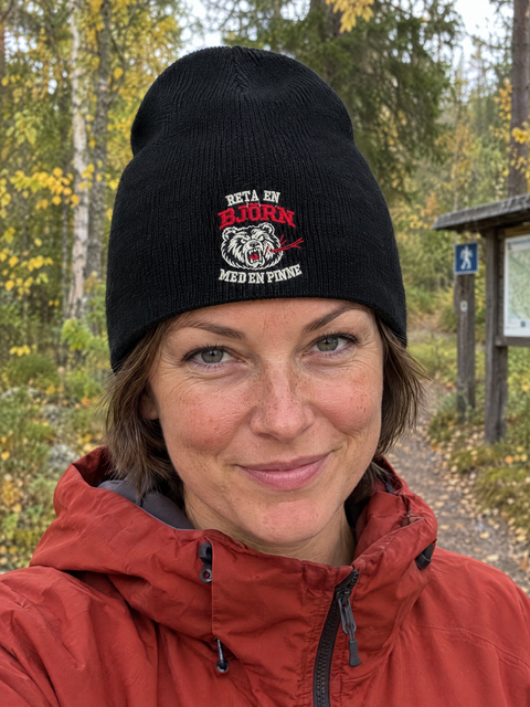 Svart Beanie uten oppbrett med bjørnebroderi på modell utendørs
