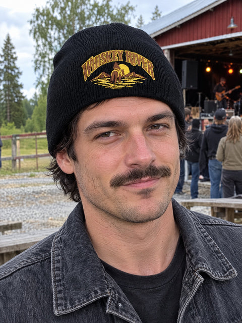 Whiskey River på svart Hatitude Beanie, buren av en yngre vuxen.